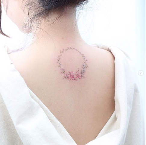 Hình xăm vòng hoa nữ tính trên sống cổ.
