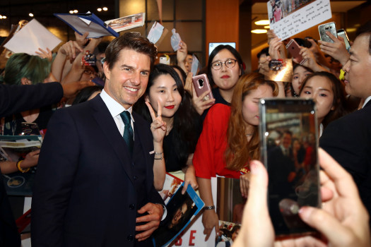 Tom Cruise vui vẻ chụp ảnh cùng fan trên thảm đỏ. Ảnh: Getty Images.