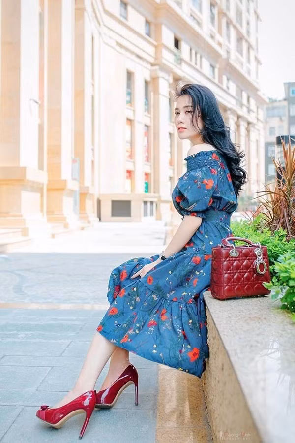 Cô diện chiếc váy xanh hoa đỏ phối với giày cao gót đỏ và túi xách đỏ hết sức sang chảnh.
