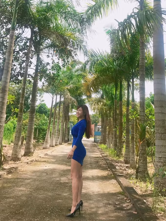 Cô mặc chiếc váy xanh ngắn khoe đôi chân dài miên man.