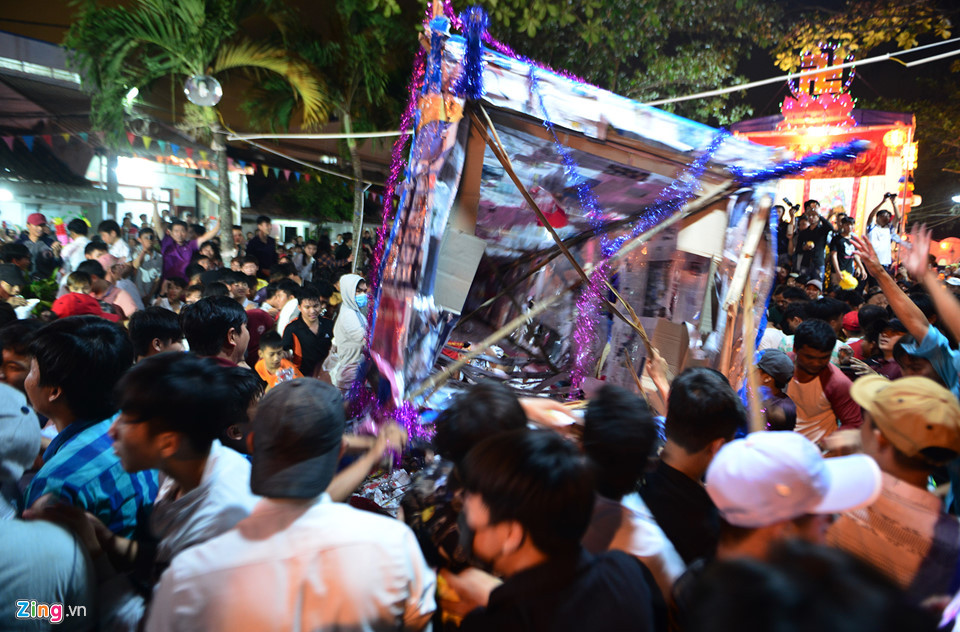 Kệ đặt bánh, trái cũng bị đưa lên, hạ xuống để những người ở dưới nhặt đồ cúng rơi vãi.