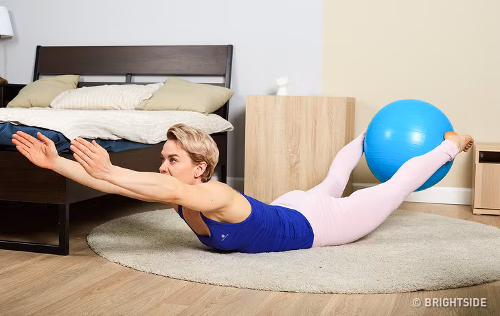 Thể dục với bóng: Nằm sấp, mở rộng cánh tay đưa thẳng ra phía trước, kẹp bong ở chân và nâng đầu gối. Giữ trong 10 giây, thả lỏng và sau đó thực hiện thêm vài lần nữa. Ảnh: BS.