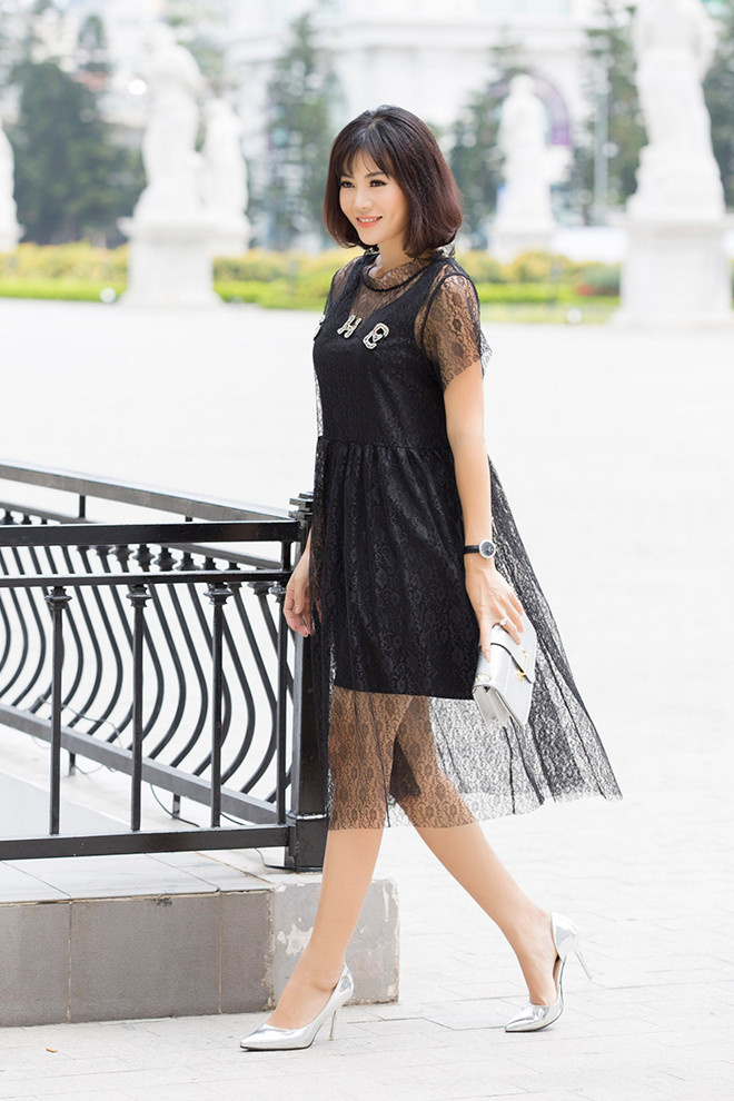 Cách ăn mặc của Thanh Hương giúp cô trông trẻ trung hơn so với tuổi thật. Chiếc váy ren đen phối với túi clutch tay hiện đại và sang chảnh.