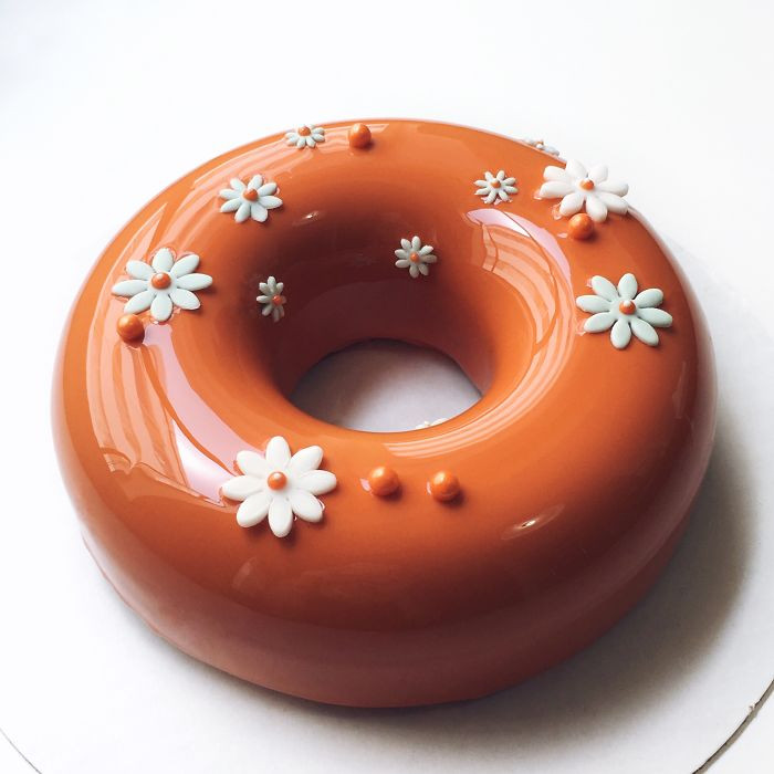 Bánh màu cam nổi bật hơn với những chiếc hoa trắng bằng socola.