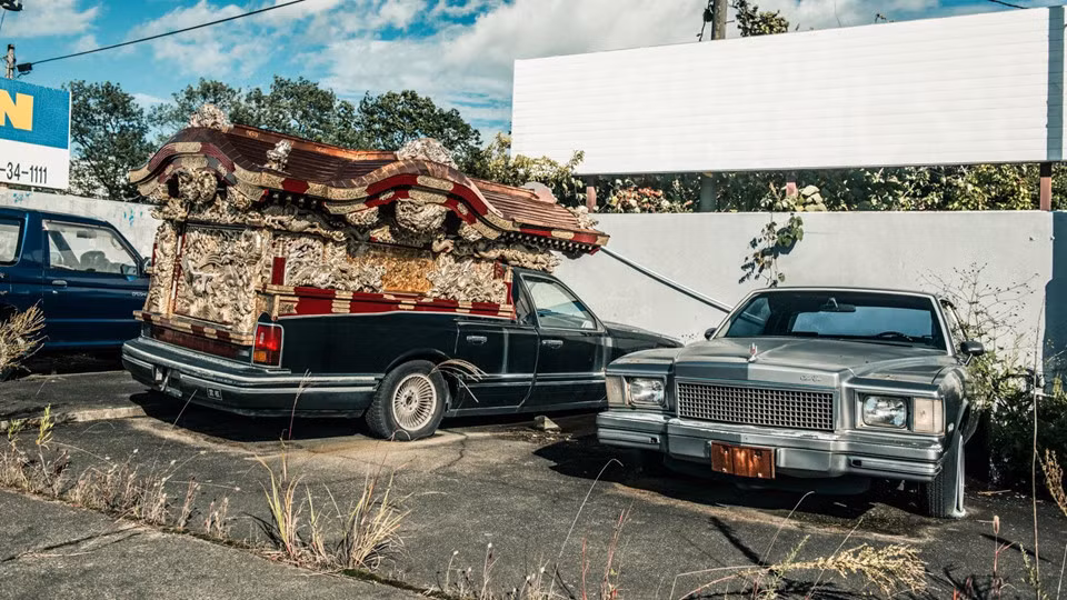 Kế đó là một chiếc Cadillac đời cũ và một chiếc xe tang cải biến từ Lincoln Town Car.