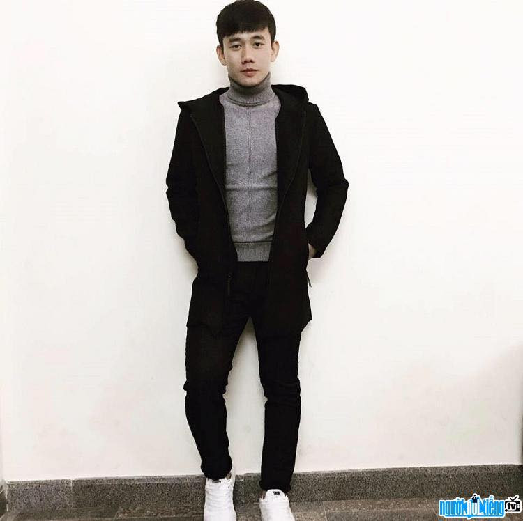 Anh chàng trông khỏe khoắn trong bộ đồ đen và giày thể thao trắng.