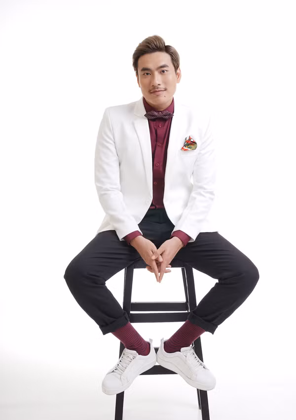 Anh chọn set đồ đơn giản với sơ mi đỏ và áo vest trắng tạo nét trẻ trung. 