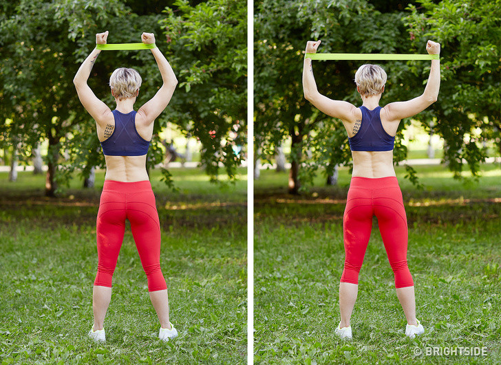 Bài tập cho bắp tay và cơ tam đầu: Đặt dây đàn hồi quàng qua 2 cổ tay và giơ tay lên. Dùng hết sức đẩy 2 cánh tay ra hai bên và lại thu tay vào vị trí ban đầu. Lặp lại 10-15 lần.