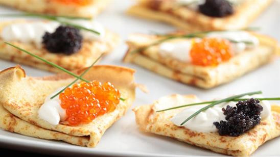 Bánh Blini: Đến Nga, bạn có thể thưởng thức món bánh đặc trưng này ở bất cứ con phố nào. Blini tròn rắn được nấu trên các vỉ nướng với nguyên liệu ăn kèm như thịt nguội, phô mai hoặc trứng cá muối đỏ.