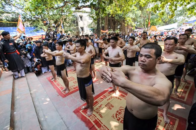 16 thanh niên khỏe mạnh tham gia hội vật gọi là quân cầu được chia làm bốn giáp (mỗi giáp bốn người), bốn giáp lại được chia làm hai đội (mỗi bên tám người) gọi là giáp trên và giáp dưới. (Ảnh: Minh Sơn/Vietnam+)