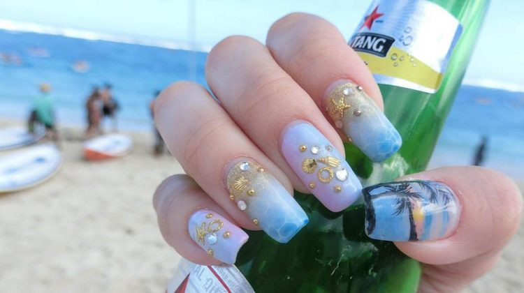 Bên cạnh những vỏ sò màu vàng óng, họa tiết cây dừa cũng khá phổ biến khi vẽ móng tay chủ đề biển cả. giúp bàn tay trông trắng trẻo hơn.