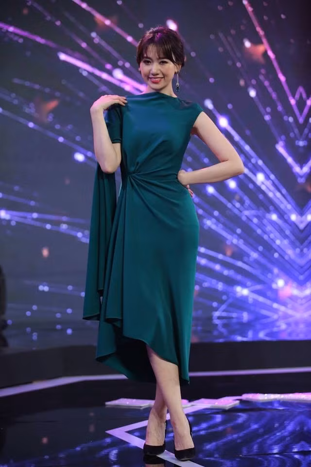 Cô chọn chiếc váy xanh thắt eo và có phần vai cách điệu cực xinh.