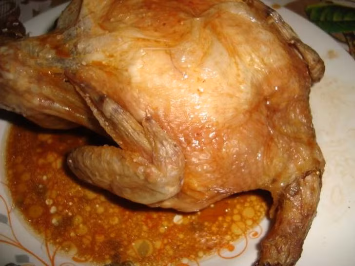 Để món gà nướng không bị khô, hãy đổ nước dùng gà lên trên.