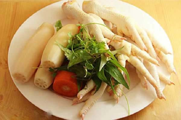 Cách làm: Bóp chân gà với muối và gừng để khử mùi hôi. Tiếp theo, các bạn bắc một nồi nước đun sôi rồi cho chân gà vào luộ, không đậy nắp, sau khi nước sôi tầm khoảng 10 phút thì các bạn vớt chân gà ra. Chuẩn bị sẵn một chậu nước có pha giấm cùng với vài viên đá lạnh, cho toàn bộ chân gà vào đó. Sau khi đã ngâm gà xong, các bạn dùng một con dao thật sắc vả tiến hành rọc một đường dọc theo chân gà, lấy mũi nhao ấn vào và tách hết xương ra ngoài.