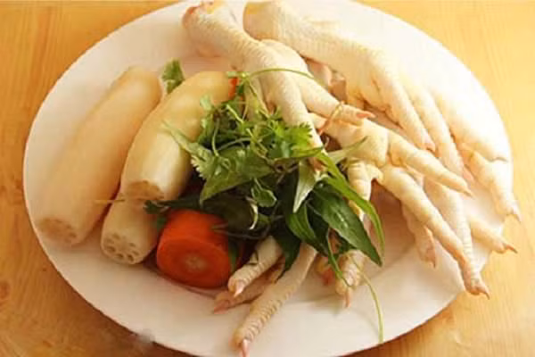 Cách làm: Bóp chân gà với muối và gừng để khử mùi hôi. Tiếp theo, các bạn bắc một nồi nước đun sôi rồi cho chân gà vào luộ, không đậy nắp, sau khi nước sôi tầm khoảng 10 phút thì các bạn vớt chân gà ra. Chuẩn bị sẵn một chậu nước có pha giấm cùng với vài viên đá lạnh, cho toàn bộ chân gà vào đó. Sau khi đã ngâm gà xong, các bạn dùng một con dao thật sắc vả tiến hành rọc một đường dọc theo chân gà, lấy mũi nhao ấn vào và tách hết xương ra ngoài.