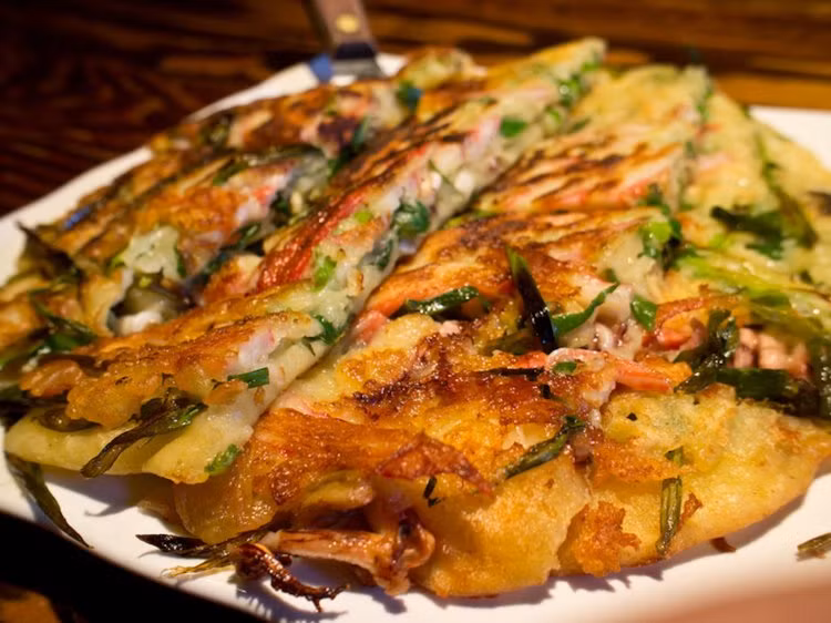 Bánh rán hải sản Hàn Quốc - pajama haemul - là món ăn nhẹ ngon tuyệt hảo. Bánh này gồm nhân hải sản, kim chi, hành lá và cả một loại rau quả.