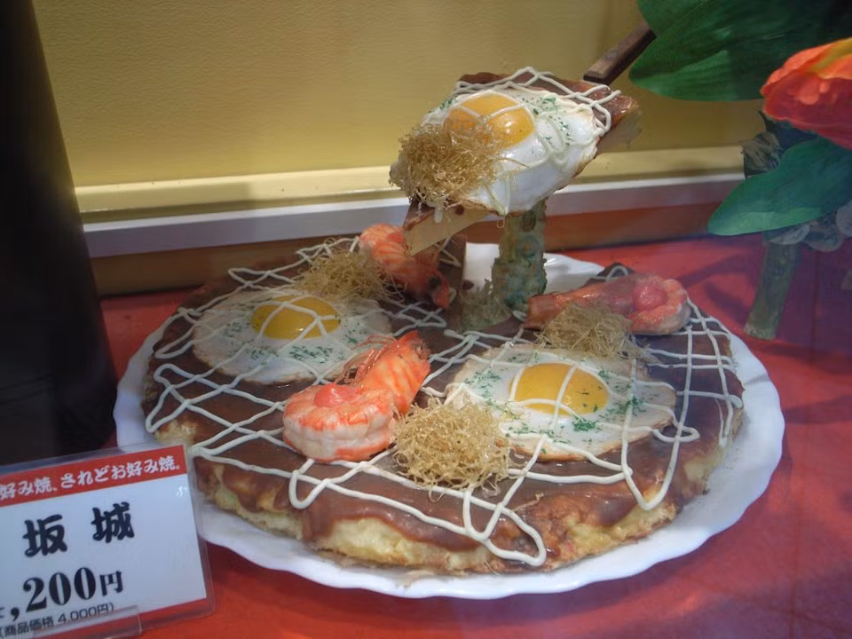 Okonomiyaki là món bánh rán mặn, thơm ngon của Nhật Bản. Chiếc bánh làm từ bột, trứng kết hợp với rau và hải sản. Sau đó rán và rắc thêm chút gừng ngâm, sốt mayonnaise.