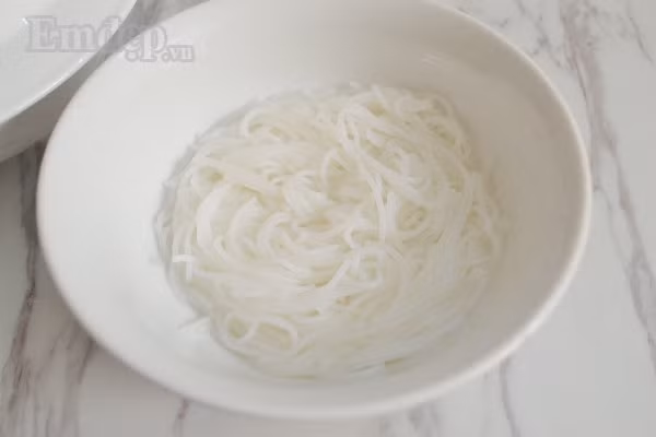 Bước 6: Bún tươi trụng sơ cho nóng mềm. Cuối cùng là cho bún vào bát thịt và chang thêm nước dùng mới còn nóng hổi vào và thưởng thức.