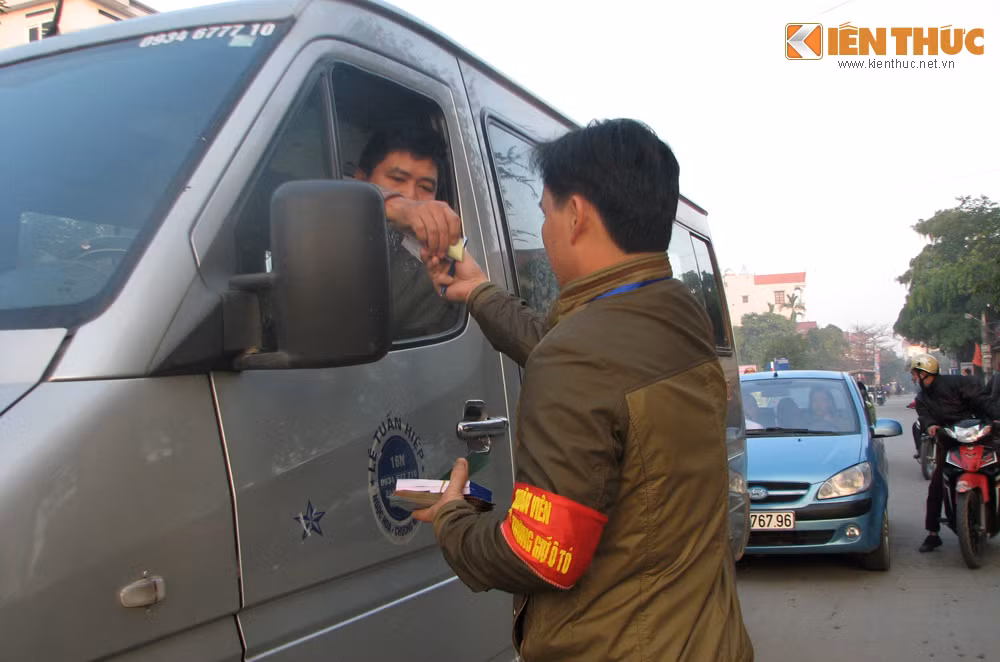 Một lái xe đang nhận vé xe từ bộ phận điều tiết bến đỗ của lễ hội chùa Hương.