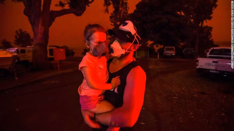 Người dân địa phương phải đeo khẩu trang tại Mallacoota ngày 4/1. Cháy rừng khiến bầu trời ở Mallacoota trở nên đỏ rực.