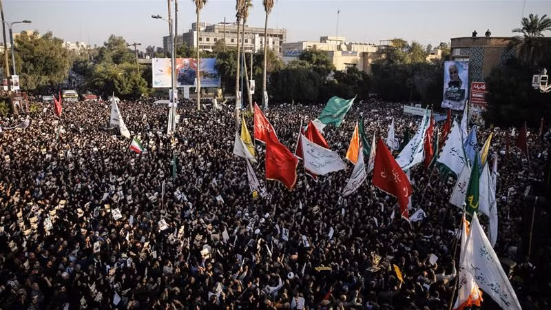 Những người đưa tang giương cao tấm chân dung của tướng Soleimani.