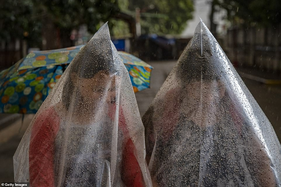 Người dân phải trùm kín người để tránh tro bụi khi đi ra ngoài đường.