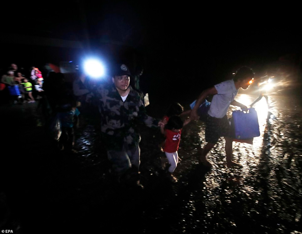 Cảnh sát sơ tán người dân đến nơi an toàn sau khi núi lửa Taal phun trào.