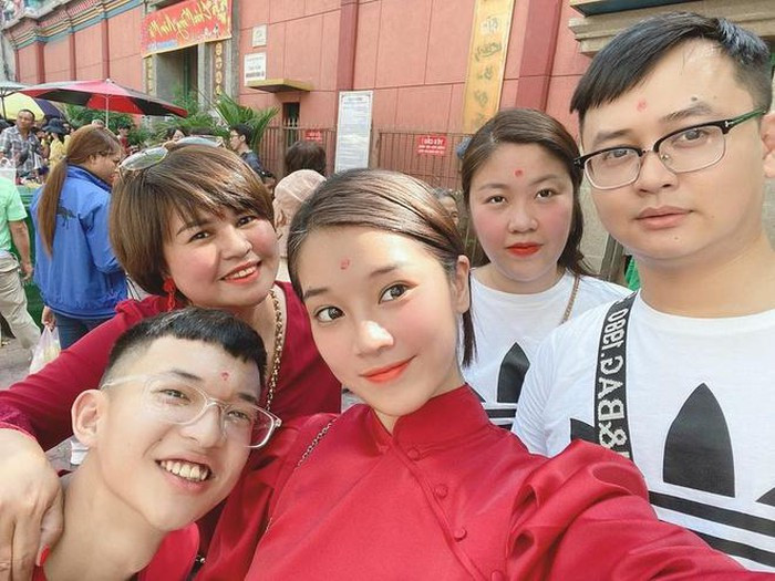 Hoàng Yến Chibi và gia đình đón Tết tại TP.HCM. Nữ ca sĩ lựa chọn bộ áo dài cách tân đầy nữ tính, kết hợp với kiểu tóc và lối trang điểm giản dị để đi chùa đầu năm.