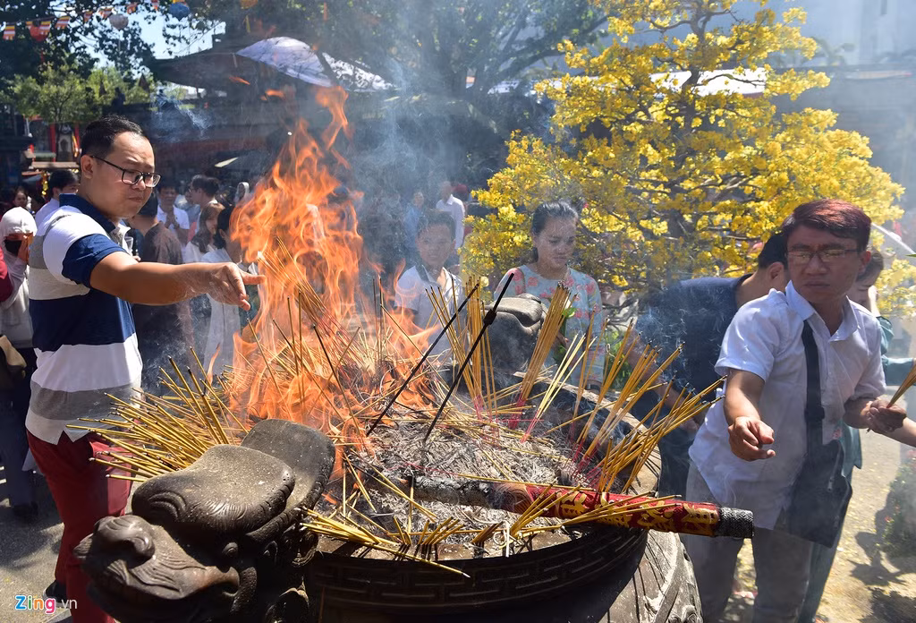 Lư hương lớn giữa lối vào chùa liên tục kín đầy, bốc cháy thành lửa. Việc cắm hương gặp khó khăn do nóng nên nhiều người phải ném vào.