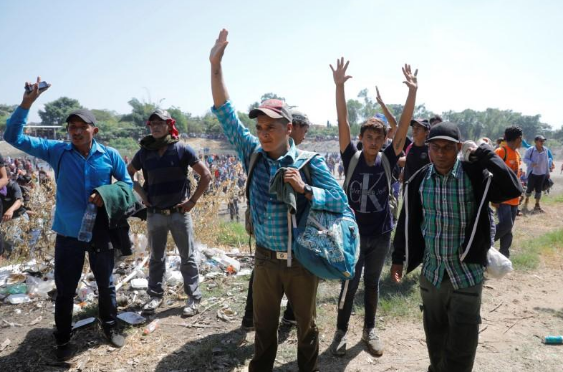 Đoàn di dân giơ tay lên khi họ đi qua khu vực biên giới Mexico-Guatemala ở Ciudad Hidalgo, Mexico, ngày 20/1.