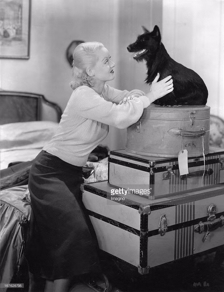 Nữ minh tinh màn bạc Mỹ Bette David tạo dáng chụp ảnh bên một chú chó nhỏ, năm 1930. Ảnh: Getty.