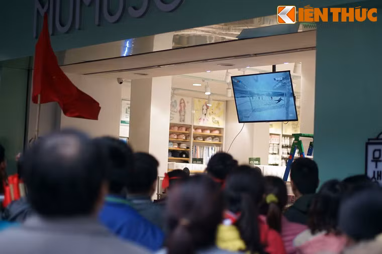 Người hâm mộ xem cảnh quay lại pha ghi bàn của Quang Hải từ chiếc TV của một cửa hàng mỹ phẩm Hàn Quốc.
