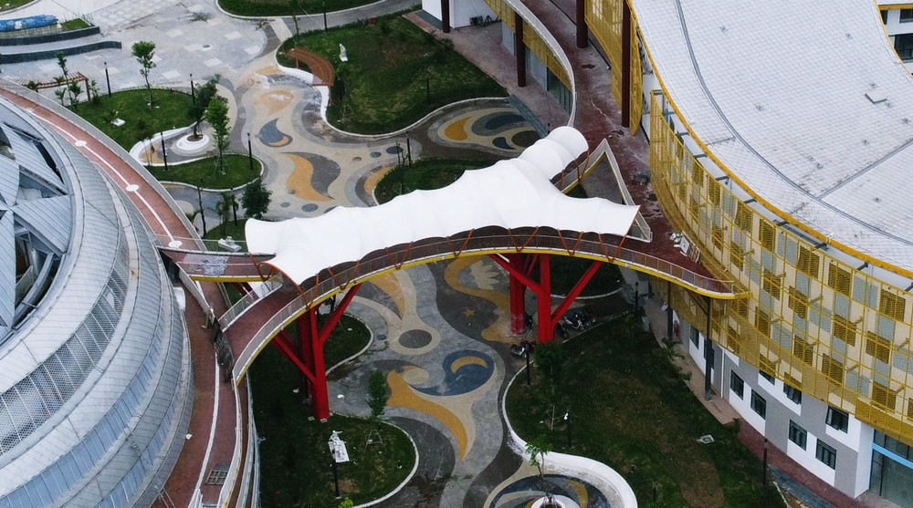 Giữa hai khối nhà A và B kết nối với nhau bằng cầu đi bộ hình chữ X, với đường nét mềm mại nằm ở khu vực tầng 3.