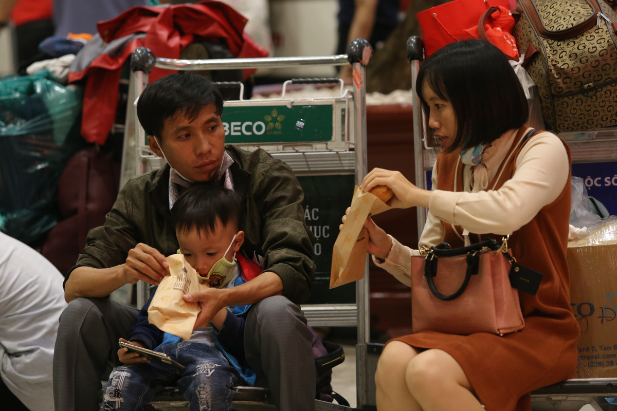 Nhiều gia đình tranh thủ ăn tạm bánh mình trong lúc chờ đợi.