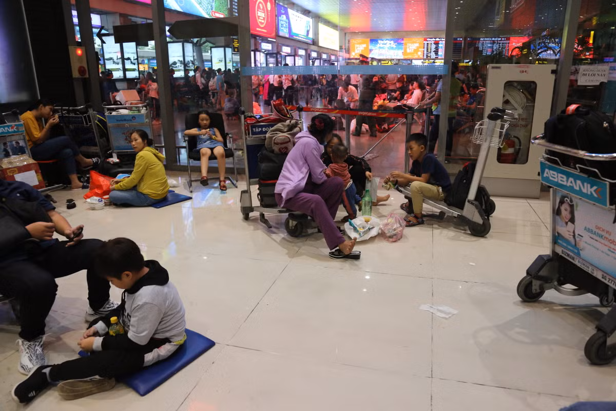 Một số chuyến bay bị chậm trễ, hoãn thời gian bay, buộc hành khách phải ngồi chờ tại sảnh nhiều giờ liền.