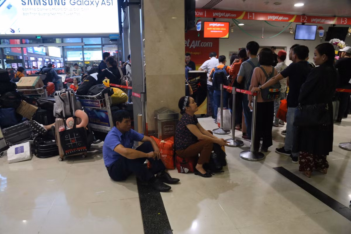 Người dân tỏ ra mệt mỏi vì phải xếp hàng nhiều giờ đồng hồ tại sân bay Tân Sơn Nhất.