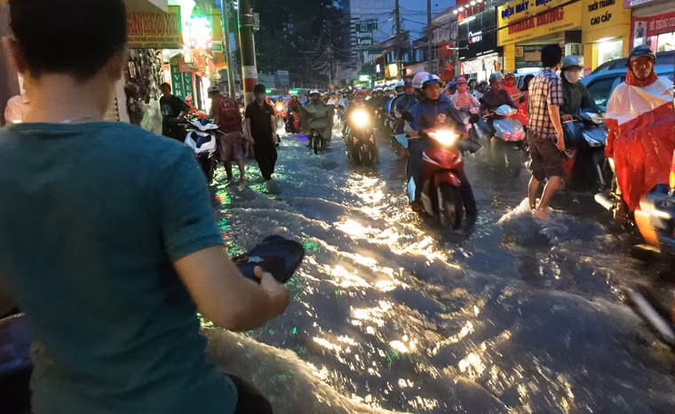Đường Võ Văn Ngân, tuyến đường trung tâm quận Thủ Đức nước mưa từ đầu dốc ào ào đổ xuống đã khiến nhiều người bị ngã.