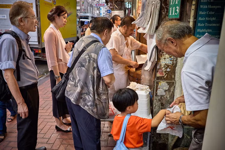 Khách hàng xếp hàng chờ mua đồ ăn sẵn trong một quầy hàng ăn ở phố Thượng Hải, Yau Ma Tel. Nét văn hóa đa dạng ở Hương Cảng thể hiện qua những nếp sống của người dân trên khắp tuyến phố.