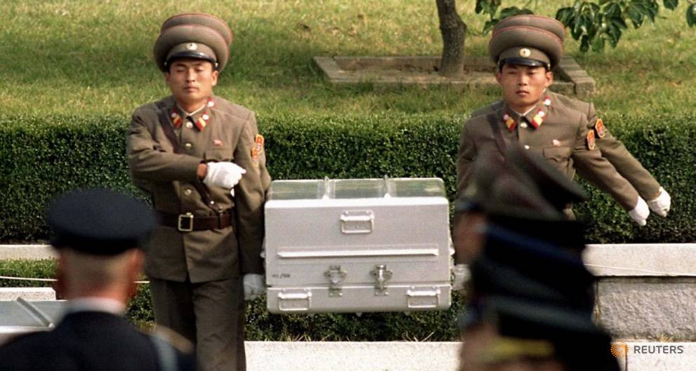 Các binh sĩ Triều Tiên khiêng quan tài chứa hài cốt được tin là của binh sĩ Mỹ trong lễ bàn giao hài cốt năm 1998. Ảnh: Reuters.