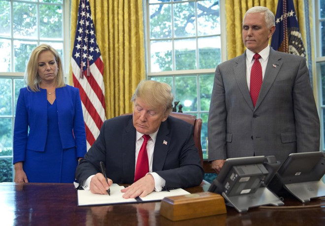 Ông Trump ký lệnh hôm 20/6, đứng cạnh là Bộ trưởng An ninh Nội địa Kirstjen Nielsen và Phó tổng thống Mike Pence. Ảnh: AP.