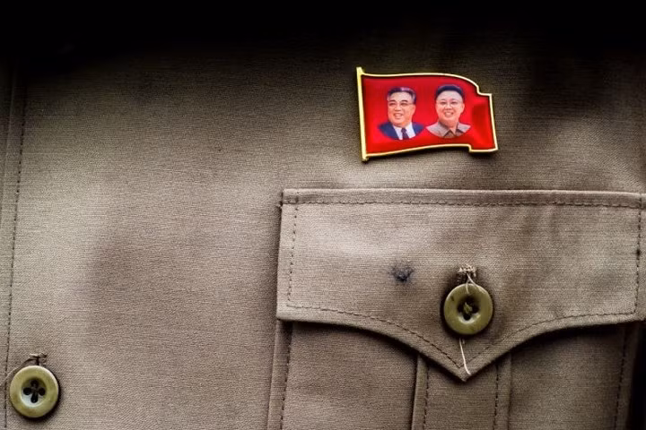 Một tấm huy hiệu hình các cố lãnh tụ Triều Tiên là Kim Nhật Thành (Kim Il-sung) và Kim Chính Nhật (Kim Jong-il).