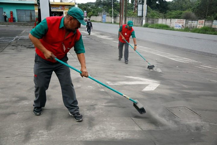 Một nhân viên đang dọn dẹp tro bụi ở lối vào nhà ga của thủ đô Guatemala City. Ảnh: Reuters.