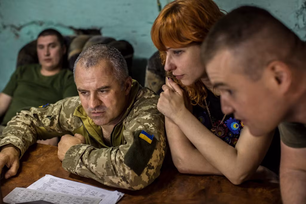 Đại úy Oleg yêu cầu sự binh sĩ tập trung vào nhiệm vụ trong hiệp 2 trận đấu sau khi nhận được loạt đạn từ phía quân nổi dậy. Ảnh: New York Times.