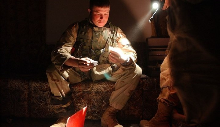 Lính Mỹ đang xem các tài liệu và bản đồ mà họ tìm thấy sau khi chiếm được một khu nhà ở mà quân Iraq mới bỏ lại.