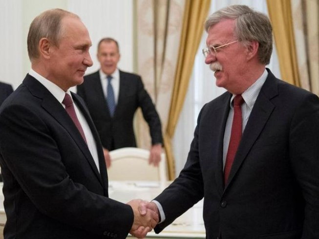 Tổng thống Nga Vladimir Putin (trái) bắt tay Cố vấn an ninh quốc gia Mỹ John Bolton trong cuộc gặp tại Điện Kremlin (Nga) ngày 27-6. Ảnh: REUTERS.
