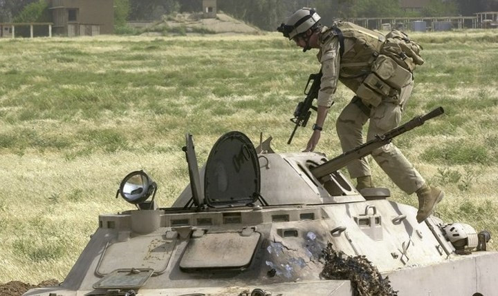 Một lính Mỹ kiểm tra một xe bọc thép Iraq để bảo đảm rằng không còn lính Iraq nào bên trong.