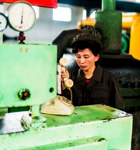 Một phụ nữ tại nhà máy phân bón Hamhung trả lời điện thoại.