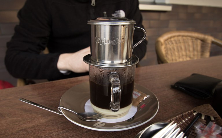  10. Cà phê Việt. Việt Nam là nước sản xuất cà phê lớn thứ hai trên thế giới. Cách tốt nhất để thưởng thức cà phê như người Việt Nam là gọi cà phê sữa đá. Dù đơn giản nhưng có vẻ món đồ uống này là một phát kiến thiên tài. Cà phê xay sẽ được đưa vào phin lọc, thêm nước nóng và để cho cà phê thấm qua nhỏ giọt vào cốc bên dưới..." - Piumi Rajapaksha.