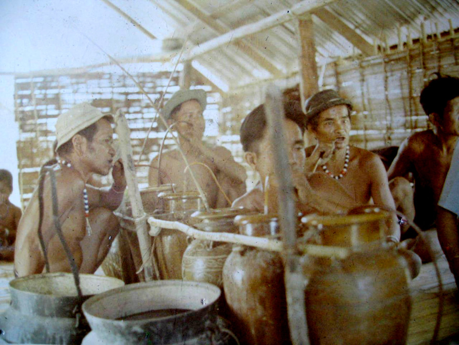 Nhân công người Việt làm việc cho quân đội Mỹ thưởng thức rượu cần trong một nhà sàn gần sân bay Cheo Reo, 1970. Ảnh: 203rdhawkeyes.net.