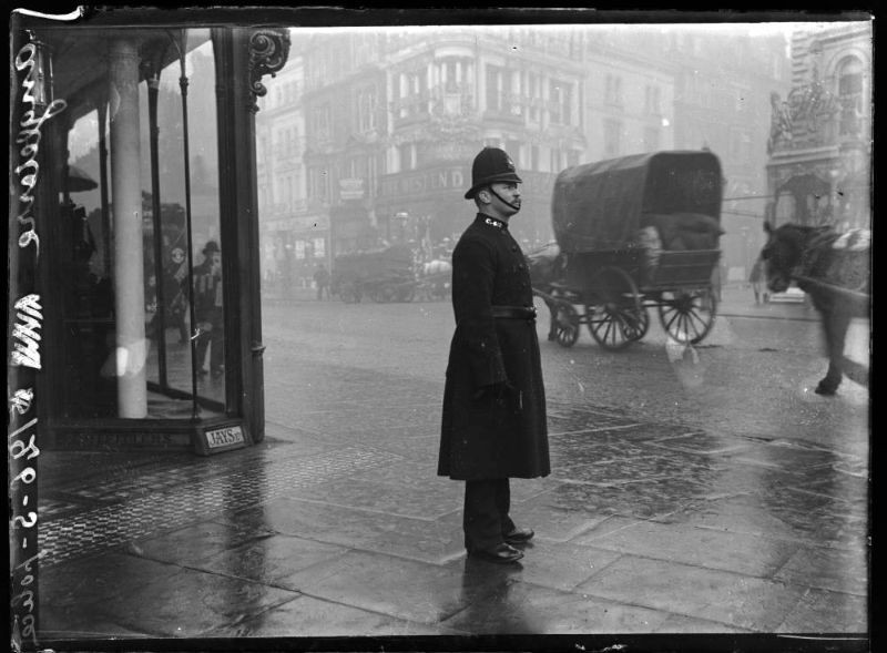 Người cảnh sát đứng trên đường phố London trong cơn mưa. Ảnh: Chusseau-Flaviens.